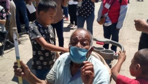 Niños de 7 y 11 años llevaron a su abuelo en un coche de bebé para ser vacunado en México